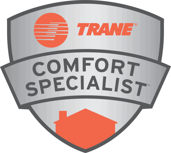 A silver badge with the orange Trane logo and the words TRANE COMFORT SPECIALIST in black text, with an orange silhouette of a house at the bottom.